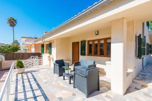 eine Terrasse mit Stühlen und ein Haus in der Unterkunft S Olivera in Can Picafort