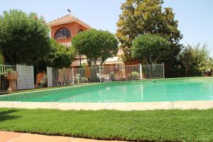 a swimming pool in a yard with a fence and trees at El jardín de la abuela in Granada