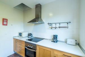 a kitchen with a sink and a stove top oven at Villa Eduard in Binibeca