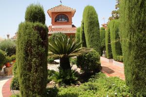 un jardín con árboles y un edificio de fondo en El jardín de la abuela, en Granada