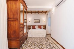 a bedroom with a bed and a dresser at Casa de los Abuelos 20 in Vejer de la Frontera