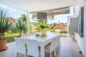 una sala da pranzo bianca con tavolo e sedie bianchi di Villa Son Veri de la Marina a El Arenal