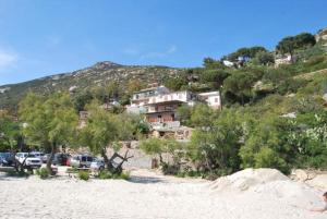 eine Gruppe von Autos, die am Strand mit einem Berg geparkt sind in der Unterkunft Appartamenti Fetovaia Elicriso in Fetovaia