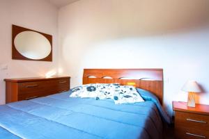 ein Schlafzimmer mit einem blauen Bett und zwei Nachttischen in der Unterkunft Villetta Ivana in Marciana