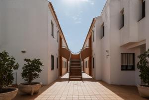 チクラナ・デ・ラ・フロンテーラにあるApartamento Aldea del Cotoの二棟の間の階段のある廊下