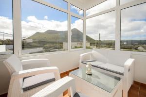 a living room with a table and chairs and windows at Apartamento Ye in Haría