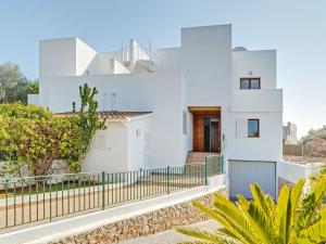 una casa blanca con una valla delante en Montevela, en Cala d´Or