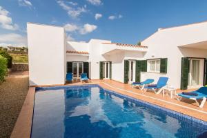 een villa met een zwembad en een huis bij Villa Eduard in Binibeca