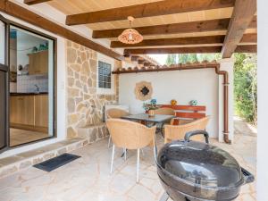 un patio con tavolo, sedie e parete in pietra di Sa Barraca a Cala Santanyi