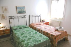 a bedroom with two beds and a window at Il giardino nel sole Bilo in Capoliveri