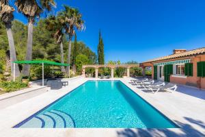 ein Swimmingpool mit Stühlen und ein Haus in der Unterkunft Santa María in Artá