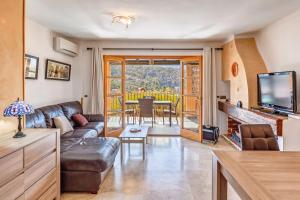 a living room with a couch and a television at Montemar 33 in Port de Soller