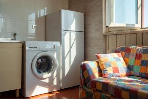 eine Küche mit einer Waschmaschine und einem Sofa in der Unterkunft Casa Vacanza Marina in Andrano