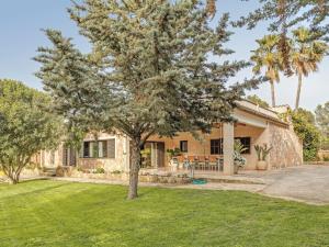 una casa con un albero nel cortile di El Bosque a Urbanicacion ses palmeres