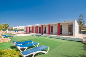 マオーにあるVilla en Menorcaの建物前の芝生の椅子群