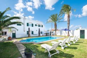 a villa with a swimming pool and palm trees at Villa en Son Gall Ciutadella in Ciutadella