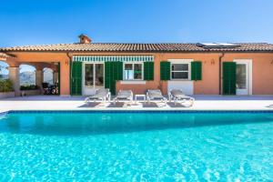 ein Haus mit einem Pool mit Stühlen und einem Haus in der Unterkunft Santa María in Artá