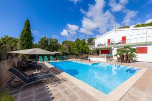 a swimming pool in front of a building at Es Pins Gran in Font de Sa Cala