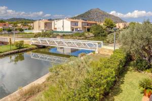 a white bridge over a river with houses at Que Bo in Alcudia