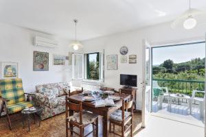 a living room with a table and a couch and a television at Il giardino nel sole Bilo in Capoliveri