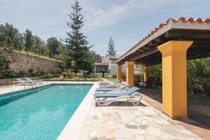 ein Swimmingpool mit Liegestühlen neben einem Haus in der Unterkunft Can Joan Vich I in Santa Eulària des Riu