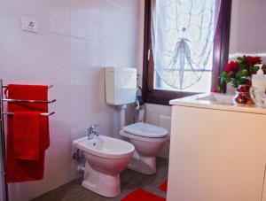 a white bathroom with a toilet and a sink at The History Apartment in Montagnana