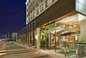 a large building with glass windows at night at Hotel Coco Grand in Takasaki