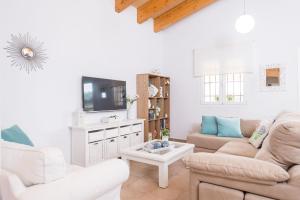 een woonkamer met 2 banken en een tv bij S'hortet in Alcudia