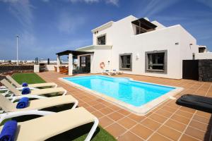 una villa con piscina frente a una casa en Aguamarina 4, en Playa Blanca