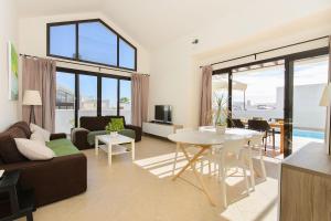 een woonkamer met een bank en een tafel bij Villa Luna in Playa Blanca