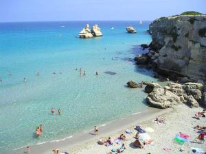 eine Gruppe von Menschen im Wasser an einem Strand in der Unterkunft Bilocale centralissimo vista mare 29 in Torre dell'Orso