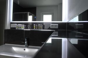 a black bathroom with a sink and a mirror at Rosbacher nun Residenz in Rosbach vor der Höhe