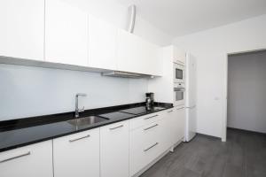 a white kitchen with white cabinets and a sink at Apartamento Marei 1 in Cala Blanca