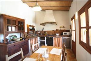 eine Küche mit einem Holztisch und einem Herd Top-Backofen in der Unterkunft Can Juanma in Sóller