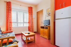 ein Wohnzimmer mit einem Kühlschrank und einem TV in der Unterkunft Apartamento con encanto y céntrico in Conil de la Frontera