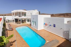 an external view of a house with a swimming pool at Las Perseidas in Costa Teguise