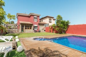 un patio trasero con piscina y una casa en Villa Marty - Mayores De 25 Años en Chiclana de la Frontera