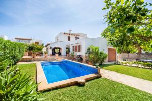 un cortile con piscina e una casa di Villa Dos Estels a Cala d´Or