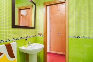 Baño verde con lavabo y espejo en Apartamento con encanto y céntrico, en Conil de la Frontera