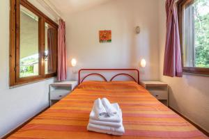 a bedroom with a bed with towels on it at Accu is Prezzus E special 50m mare in Villasimius