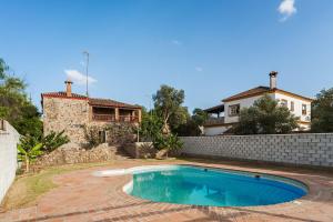 a swimming pool in front of a house at Casa de Piedra in El Cañal