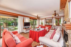 sala de estar con muebles de color naranja y chimenea en Villa Tramontana, en Lloseta