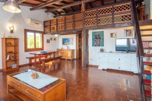 a large living room with a table and a kitchen at Splendida Vista su Tavolara in Porto San Paolo