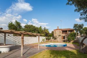 une arrière-cour avec une piscine et une maison dans l'établissement Casa de Piedra, à El Cañal