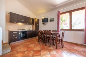 a kitchen with a table and chairs in a room at Accu is Prezzus E special 50m mare in Villasimius