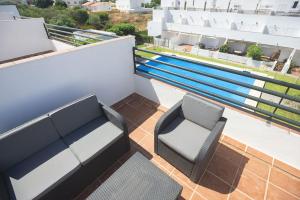 balkon z 2 krzesłami i ławką na dachu w obiekcie La Casa de la Dehesa- Sólo Familias w mieście Conil de la Frontera