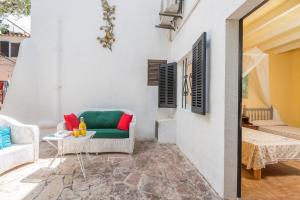 a patio with a green couch and a table at Cala Serena Beach 1 in Cala Serena