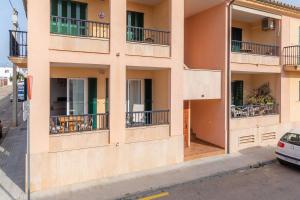 een gebouw met balkons en tafels in een straat bij Casa Vivers in Colonia de Sant Pere