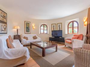 a living room with white furniture and a tv at Ses Mires in Cala Santanyi