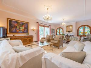 uma sala de estar com mobiliário branco e um lustre em Villa Torre em Cala Santanyi